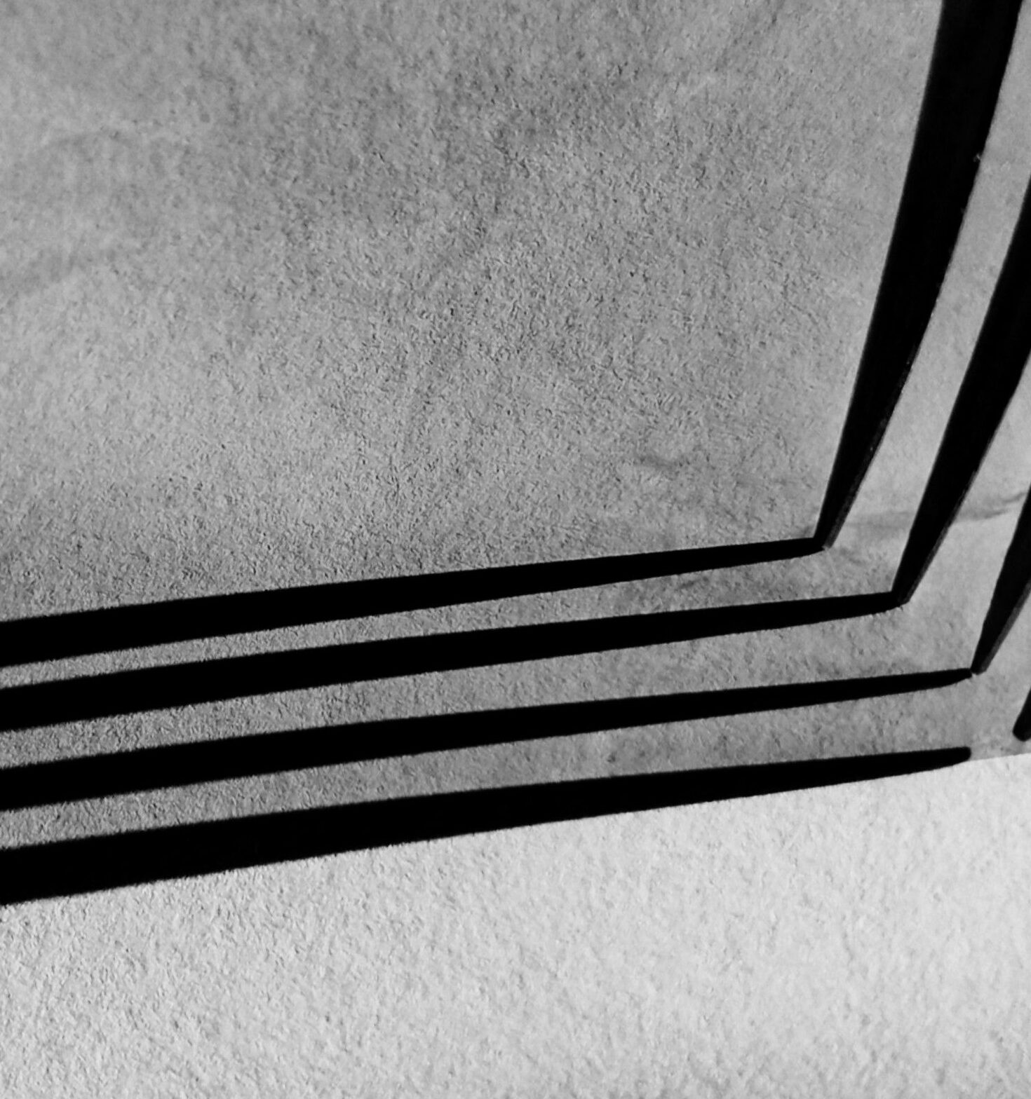 Dramatic black and white abstract with geometric patterns and shadows.